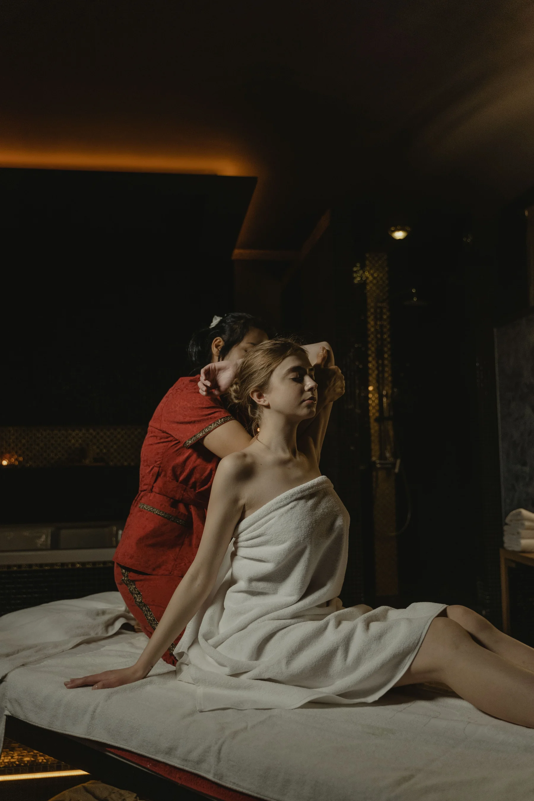 Professional massage session in a dark, elegant spa setting